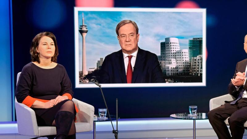 Unions-Kanzlerkandidat Armin Laschet wird auf einem Fernsehschirm gezeigt, während die Mitbewerbern von Grünen und SPD, Annalena Baerbock und Olaf Scholz im Fernsehstudio bei einer Diskussionsrunde des WDR-Europaforums in Berlin sitzen.