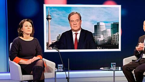 Unions-Kanzlerkandidat Armin Laschet wird auf einem Fernsehschirm gezeigt, während die Mitbewerbern von Grünen und SPD, Annalena Baerbock und Olaf Scholz im Fernsehstudio bei einer Diskussionsrunde des WDR-Europaforums in Berlin sitzen.