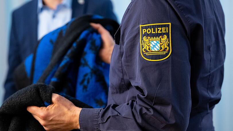 Ein Pressesprecher zeigt während einer Pressekonferenz zum Mordfall eine Vergleichsdecke.