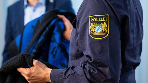 Ein Pressesprecher zeigt während einer Pressekonferenz zum Mordfall eine Vergleichsdecke.
