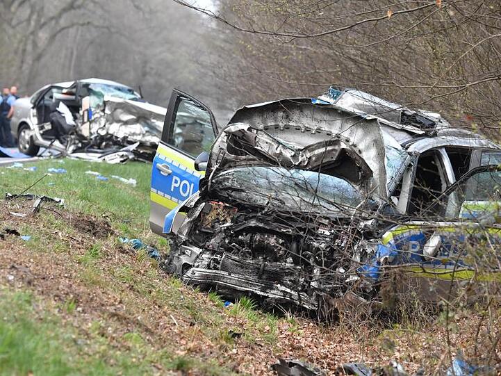 Ein völlig zerstörter Streifenwagen und ein Opel stehen nach einer Frontalkollision auf der B486 bei Langen.