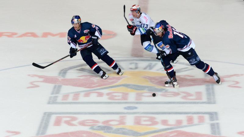 Spieler kämpfen um den Puck. Auf dem Boden ist das Logo des EHC Red Bull zu sehen. Foto: Andreas Gebert/dpa/Archivbild Spieler kämpfen um den Puck. Auf dem Boden ist das Logo des EHC Red Bull zu sehen. Foto: Andreas Gebert/dpa/Archivbild