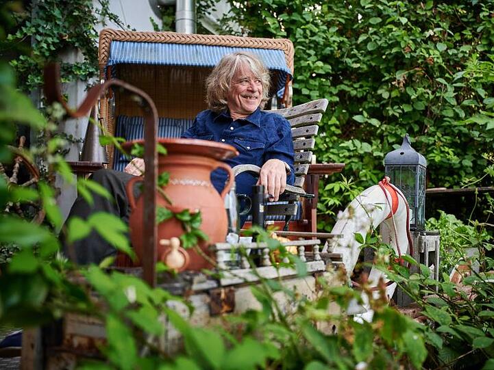 Helge Schneider sitzt auf der Terrasse seiner Wohnung. Foto: Bernd Thissen/dpa/Archivbild