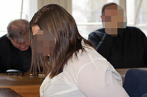 Sandra R., angeklagt wegen Misshandlung ihres schwerbehinderten Sohns, im Gerichtssaal, der vier Jahre ältere und mitangeklagte Lebensgefährte Marc P. (r) sitzt im Hintergrund.