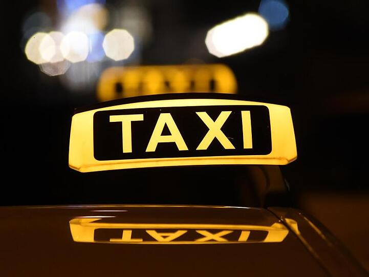 Das Dachschild eines Taxis leuchtet bei Dunkelheit. Foto: Felix Hörhager/dpa/Symbolbild