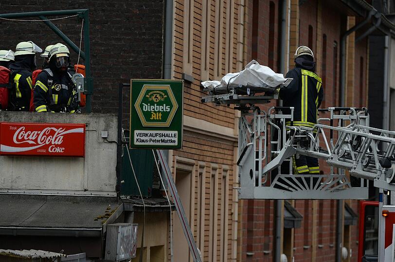 Feuerwehrleute bergen eine Leiche aus einem Haus in Duisburg (Nordrhein-Westfalen). Das Gebäude war in der Nacht vollständig abgebrannt, dabei kamen drei Personen ums Leben.