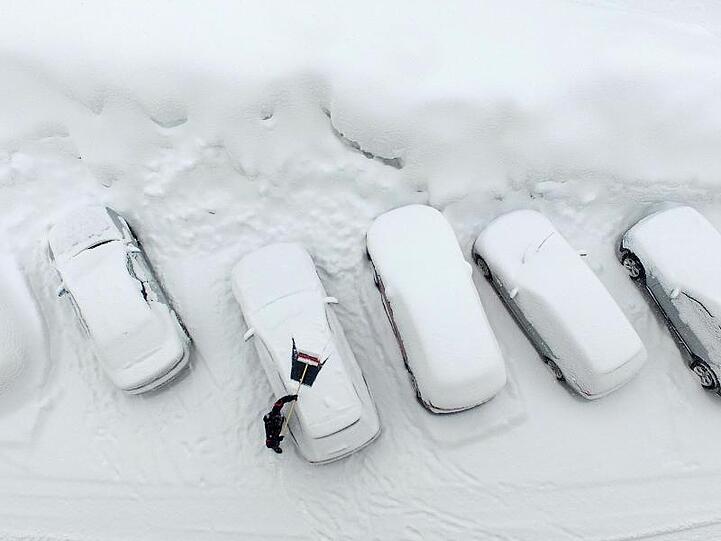 Ausgrabungen: Ein Mann befreit in Ramsau am Dachstein sein Auto von Schnee.