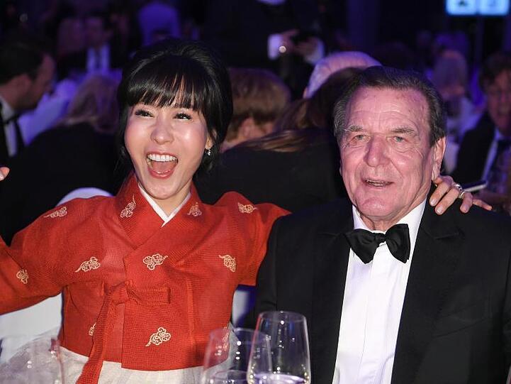 Altbundeskanzler Gerhard Schröder und seine Frau Soyeon Kim amüsieren sich.