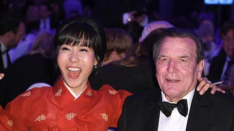 Altbundeskanzler Gerhard Schröder und seine Frau Soyeon Kim amüsieren sich.
