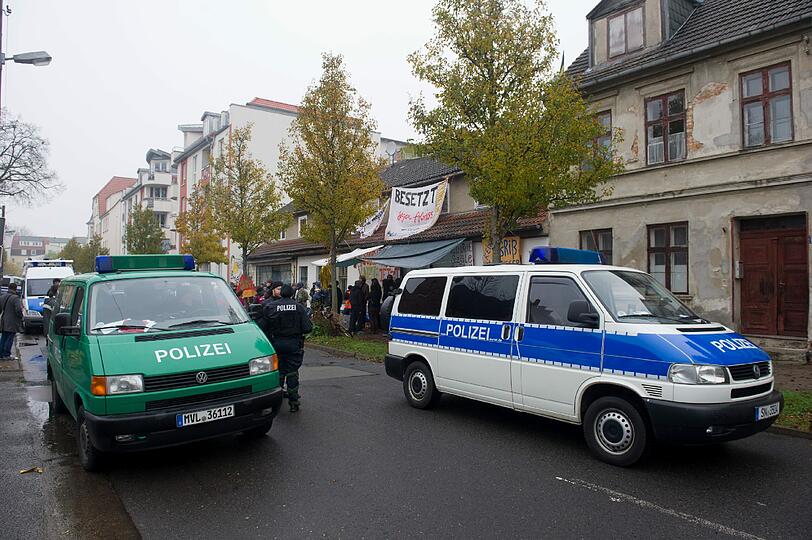 Die Besetzer werfen Konfetti, unten steht ein SEK-Kommando der Polizei: In Greifswald wurde ein besetztes Haus geräumt. Die Bilder.