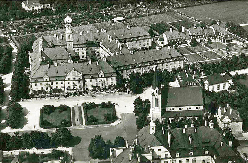 Auf dieser Aufnahme um 1936 ist das Altenheim Heilig-Geist am Dom-Pedro-Platz zu sehen. Am oberen Bildrand ist der Taxisgarten zu sehen, die Kirche rechts ist die Christuskirche.