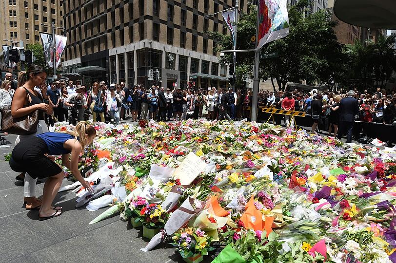 Tausende Menschen legen in der Nähe des "Lindt"-Cafés Blumen nieder.
