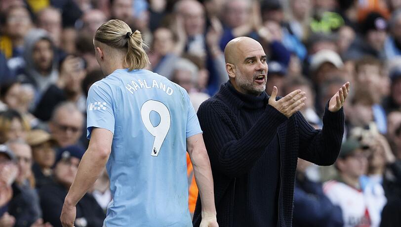 Erling Haaland (l) von Manchester City reagiert auf Trainer Pep Guardiola.