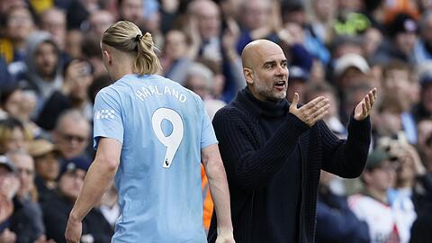 Erling Haaland (l) von Manchester City reagiert auf Trainer Pep Guardiola.