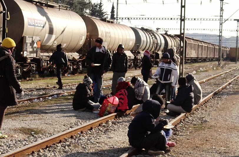 Flüchtlinge warten auf den Gleisen.