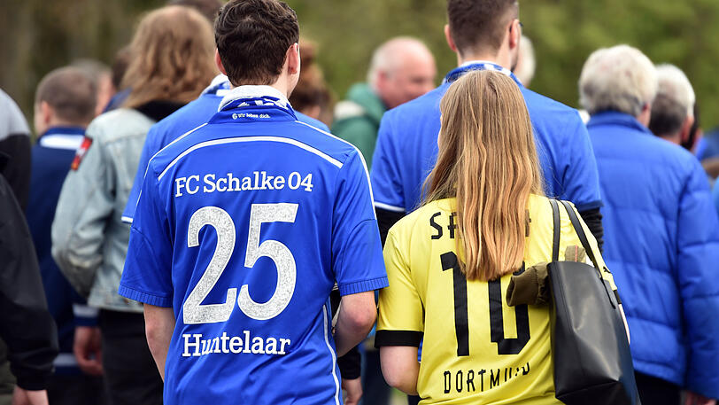 Eintracht im Revier: Ein Schalke-Fan und eine Anhängerin von Borussia Dortmunder gehen gemeinsam in Gelsenkirchen zu Stadion von Schalke (Bild aus dem April 2017).