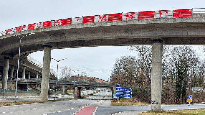 Die Tatzelwurmbrücke an der Auffahrt zur A9 in Freimann: rote und weiße Felder. Mit den drei Buchstaben FCB und MRP – die Abkürzung für "Munichs Red Pride".