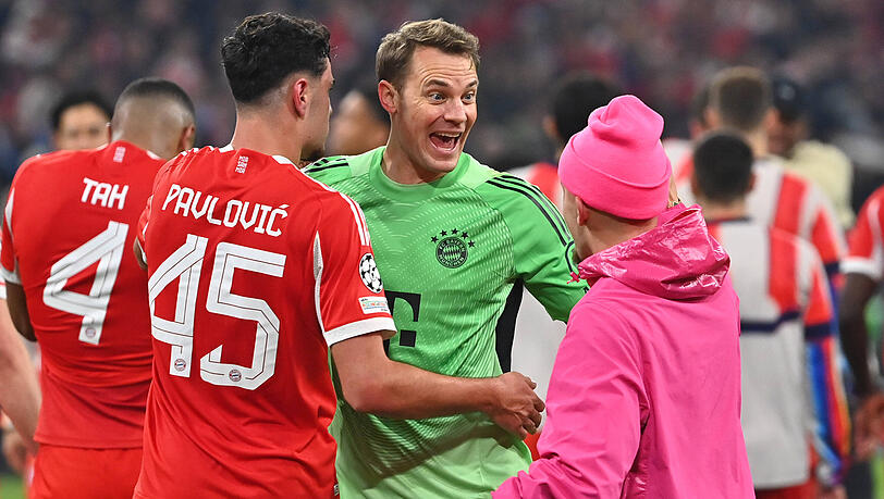 Sieht bei zwei Gegentoren gegen Real Madrid schlecht aus und darf am Ende doch mit Aleksandar Pavlovic (l.) und Pink-Panther Lennart Karl (r.) feiern: Bayerns Torh&uuml;ter und Kapit&auml;n Manuel Neuer.