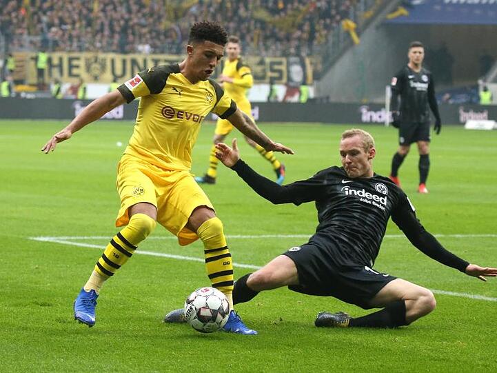 Der Dortmunder Jadon Sancho (l) wird von Frankfurts Sebastian Rode im Dribbling bedrängt.