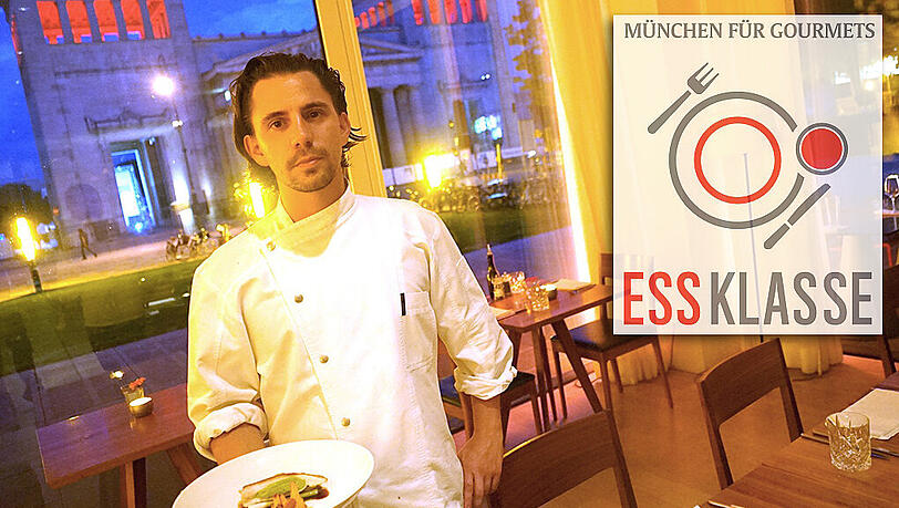 Küchenchef Michael Hausberger präsentiert im Restaurant Ella am Königsplatz den Hauptgang: Schwarzfederhuhn mit Erbse, Pfifferlingen und jungem Lauch – und draußen im Hintergrund grüßen die Propyläen. Küchenchef Michael Hausberger präsentiert im Restaurant Ella am Königsplatz den Hauptgang: Schwarzfederhuhn mit Erbse, Pfifferlingen und jungem Lauch – und draußen im Hintergrund grüßen die Propyläen.