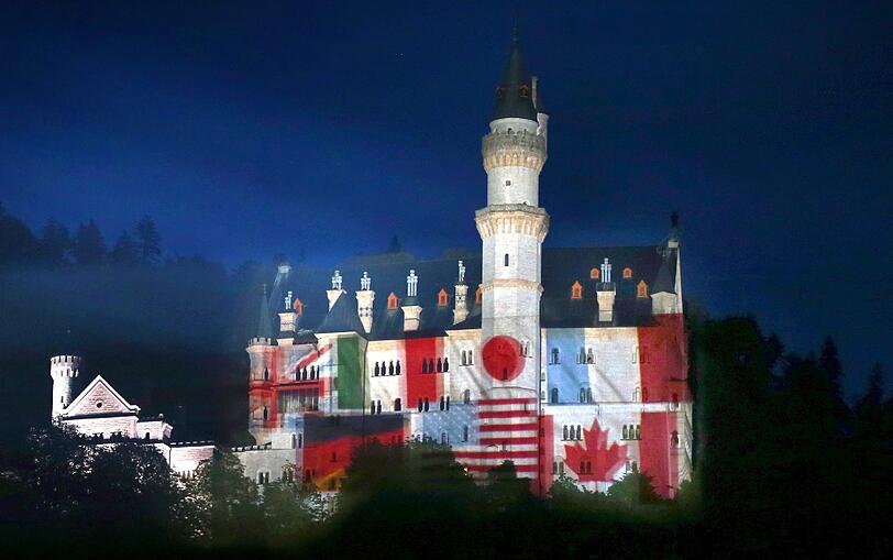 Auf das Schloss Neuschwanstein bei Hohenschwangau (Bayern) werden am 30.05.2015 Fotos der Landesfahnen der G7-Mitglieder projiziert. Das Schloss soll in den nächsten Tagen in den jeweiligen Landesfarben der G7-Staaten leuchten. Als «Zeichen der Gastfreundschaft» werden ab diesem Samstag (30.05.2015) sieben Abende lang die jeweiligen Landesflaggen auf die Frontseite des Schlosses projiziert, teilte die Bayerische Staatskanzlei am Freitag (29.05.201) in München mit.