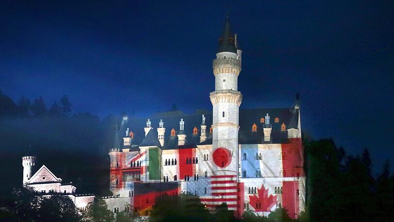 Auf das Schloss Neuschwanstein bei Hohenschwangau (Bayern) werden am 30.05.2015 Fotos der Landesfahnen der G7-Mitglieder projiziert. Das Schloss soll in den nächsten Tagen in den jeweiligen Landesfarben der G7-Staaten leuchten. Als «Zeichen der Gastfreundschaft» werden ab diesem Samstag (30.05.2015) sieben Abende lang die jeweiligen Landesflaggen auf die Frontseite des Schlosses projiziert, teilte die Bayerische Staatskanzlei am Freitag (29.05.201) in München mit. Auf das Schloss Neuschwanstein bei Hohenschwangau (Bayern) werden am 30.05.2015 Fotos der Landesfahnen der G7-Mitglieder projiziert. Das Schloss soll in den nächsten Tagen in den jeweiligen Landesfarben der G7-Staaten leuchten. Als «Zeichen der Gastfreundschaft» werden ab diesem Samstag (30.05.2015) sieben Abende lang die jeweiligen Landesflaggen auf die Frontseite des Schlosses projiziert, teilte die Bayerische Staatskanzlei am Freitag (29.05.201) in München mit.
