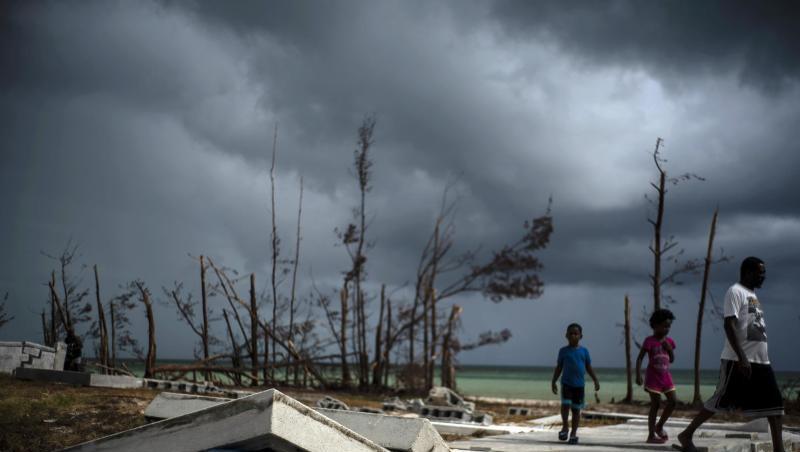 Menschen gehen an den Trümmern auf einem Friedhof auf den Bahamas vorüber. Menschen gehen an den Trümmern auf einem Friedhof auf den Bahamas vorüber.
