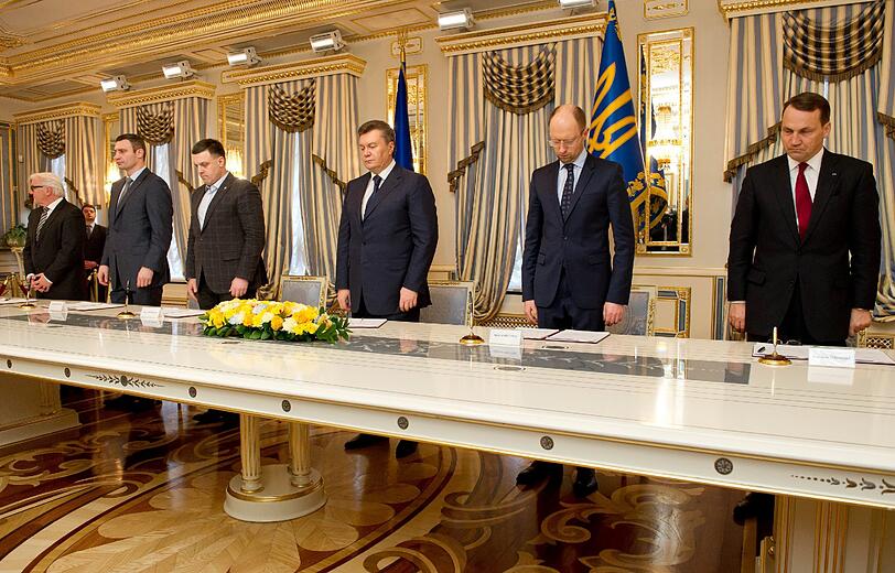 Stehend gedenken Bundesaußenminister Frank-Walter Steinmeier, Oppositionspolitiker Vitali Klitschko, Oppositionspolitiker Oleg Tjagnibok, der ukrainische Staatspräsident Viktor Janukowitsch, Oppositionspolitiker Arseni Jazenjuk und der polnische Außenminister Radoslaw Sikorski im Präsidentenpalast in Kiew der Opfer der Krise.