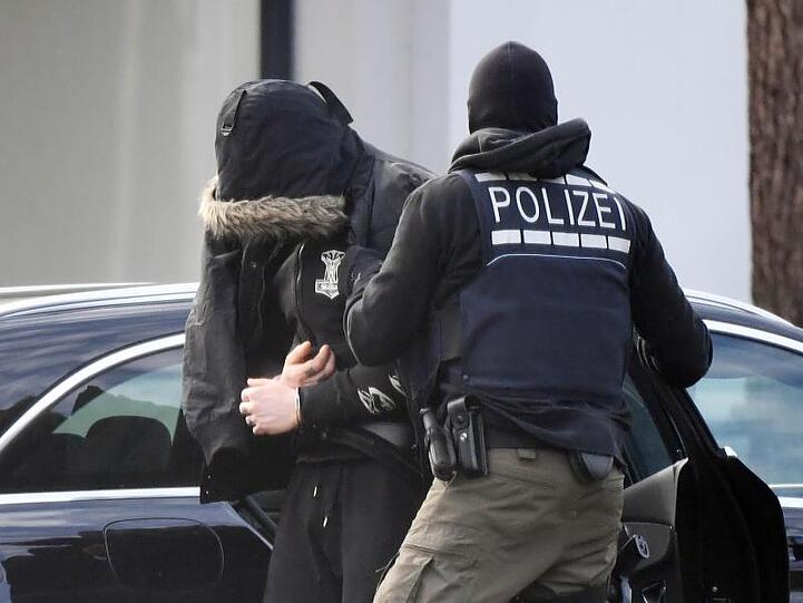 Eine Person wird von Polizisten in den Bundesgerichtshof gebracht.