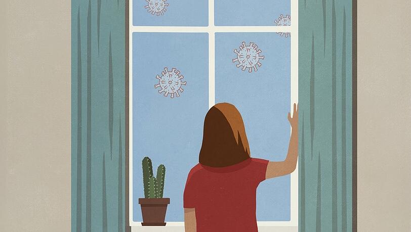 Sinnbild der Sorge: Eine Frau blickt aus dem Fenster auf Coronaviren.