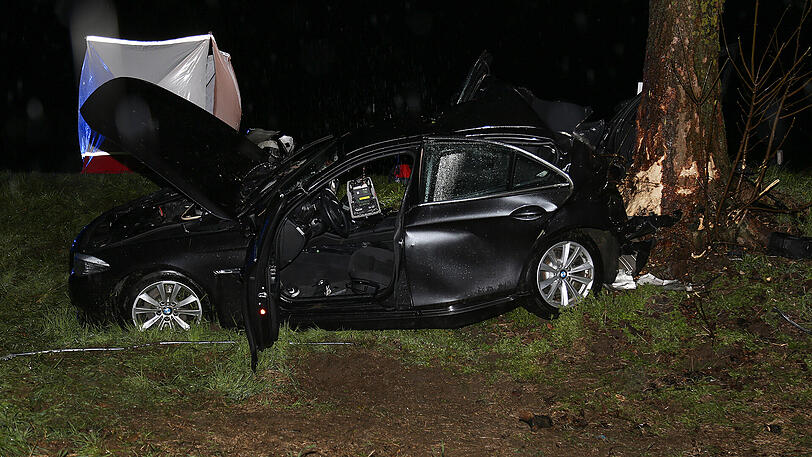 Schreckliche Bilder aus Icking: Der BMW kam von der Straße ab und prallte gegen einen Baum. Zwei 19-jährige Männer starben.