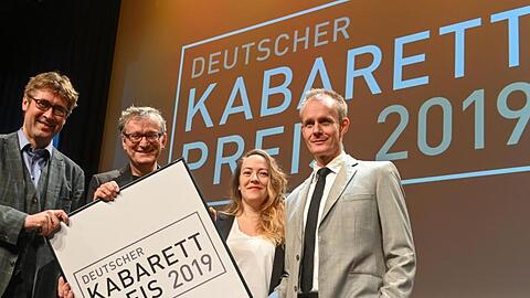Detlef Simon (Desimo, l-r), Sonderpreis-Gewinner, Moderator Frank Lüdecke, Lisa Catena, Förderpreis-Gewinnerin, und Preisträger Max Uthoff stehen bei der Verleihung des Deutschen Kabarett-Preises auf der Bühne. Foto: Berny Meyer/dpa/Archivbild