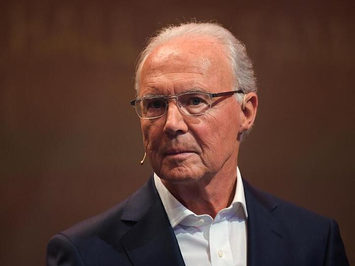Ehemaliger Fußballspieler Franz Beckenbauer steht auf einer Bühne während einer Veranstaltung. Foto: Ina Fassbender/Archivbild