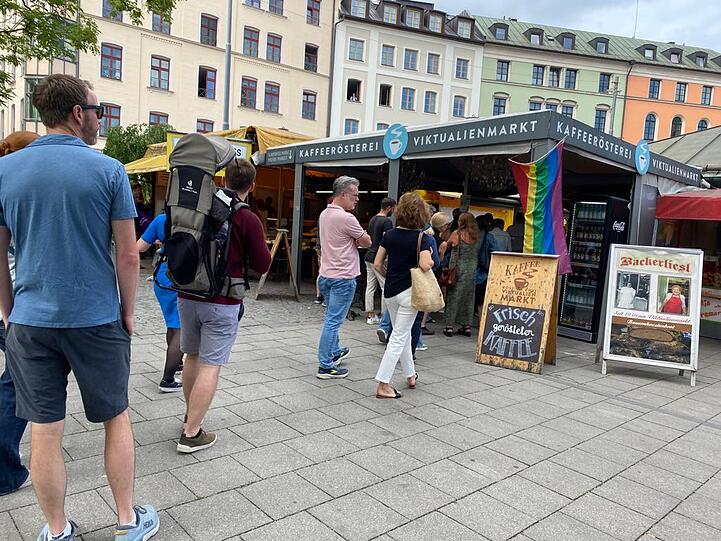 Ein einsames Fähnchen am Kaffeestand am Viktualienmarkt. Auch im Glockenbachviertel ist es am Samstag gegen 10.15 Uhr noch ruhig. Aber in der Ferne hört man ganz leise Trommeln.