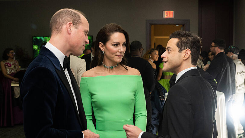 Prinzessin Kate, hier im Gespräch mit Ehemann Prinz William und Oscar-Gewinner Remi Malek, trug ein Abendkleid mit unglücklicher Farbwahl.