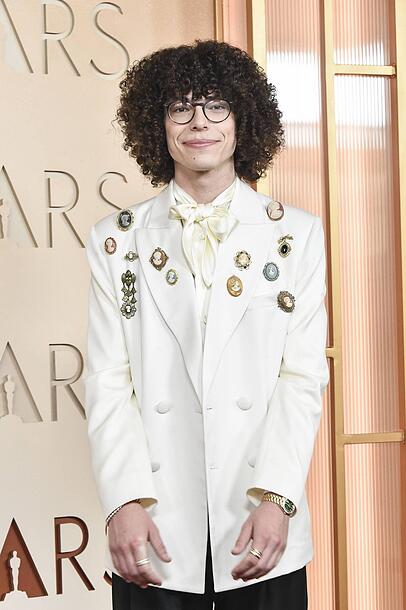 Reece Feldman: Auf jeden Fall ein Hingucker, weil so einiges nicht harmonisch wirkt. Einer der schwächsten Looks bei den Männern. Zu viel Schmuck und Accessoires. Das Hemd mit der Schleife ist sonderbar und too much. Für einen so formellen Anlass hätte ich mir etwas mehr Eleganz gewünscht. Reece Feldman: Auf jeden Fall ein Hingucker, weil so einiges nicht harmonisch wirkt. Einer der schwächsten Looks bei den Männern. Zu viel Schmuck und Accessoires. Das Hemd mit der Schleife ist sonderbar und too much. Für einen so formellen Anlass hätte ich mir etwas mehr Eleganz gewünscht.