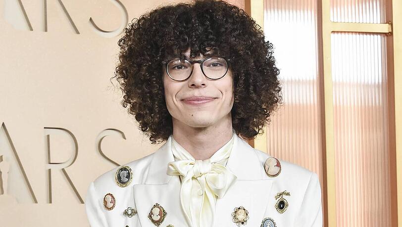 Reece Feldman: Auf jeden Fall ein Hingucker, weil so einiges nicht harmonisch wirkt. Einer der schw&auml;chsten Looks bei den M&auml;nnern. Zu viel Schmuck und Accessoires. Das Hemd mit der Schleife ist sonderbar und too much. F&uuml;r einen so formellen Anlass h&auml;tte ich mir etwas mehr Eleganz gew&uuml;nscht.