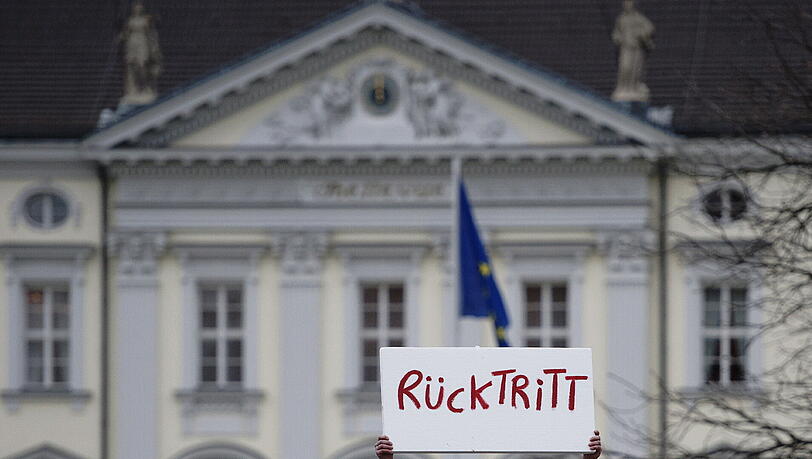 Ein Mann protestiert in Berlin vor Schloss Bellevue mit einem Schild mit der Aufschrift "Rücktritt". In der Spitze des schwarz-gelben Regierungsbuendnisses hat man den Rücktritt von Bundespraesident Christian Wulff bereits erwartet. Ein Mann protestiert in Berlin vor Schloss Bellevue mit einem Schild mit der Aufschrift "Rücktritt". In der Spitze des schwarz-gelben Regierungsbuendnisses hat man den Rücktritt von Bundespraesident Christian Wulff bereits erwartet.