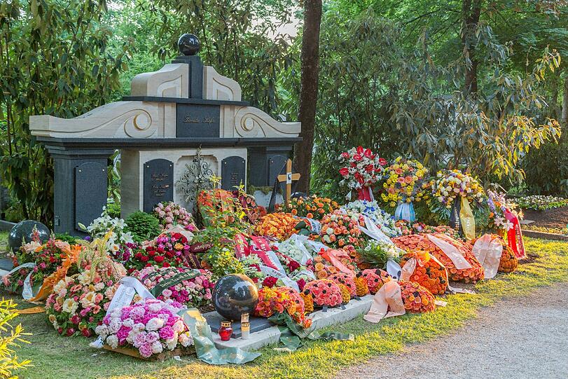 Buntes Gedenken: Das Familiengrab Gerd Käfers mit vielen Kränzen und Blumengestecken am Ostfriedhof.