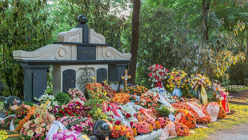 Buntes Gedenken: Das Familiengrab Gerd Käfers mit vielen Kränzen und Blumengestecken am Ostfriedhof. Buntes Gedenken: Das Familiengrab Gerd Käfers mit vielen Kränzen und Blumengestecken am Ostfriedhof.