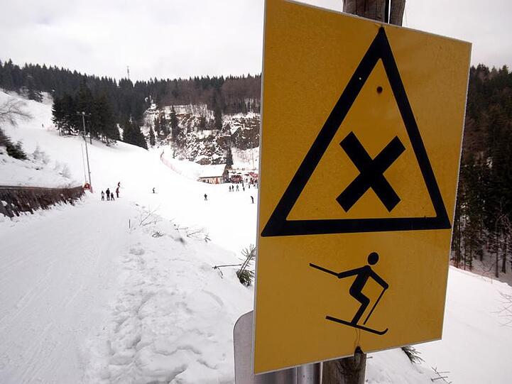 Ein Warnschild auf einer Skipiste.