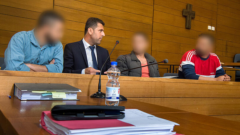 Die drei Verurteilten mit ihrem Dolmetscher im Landgericht Traunstein.