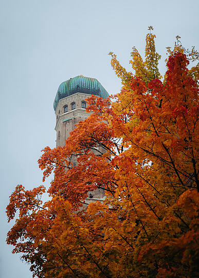 Oben grau, unten bunt: die Frauenkirche im herbstlichen München.