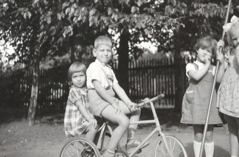 Gemeinsames Spielen mit Freundinnen in Omas Garten: Christine (l.)und ihr Bruder Rolf auf dem Fahrrad.