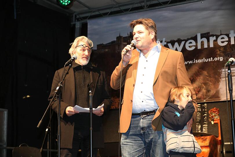 Rufus Beck führt als Moderator durch den Abend und Veranstalter Benjamin David mit seinem Kind.