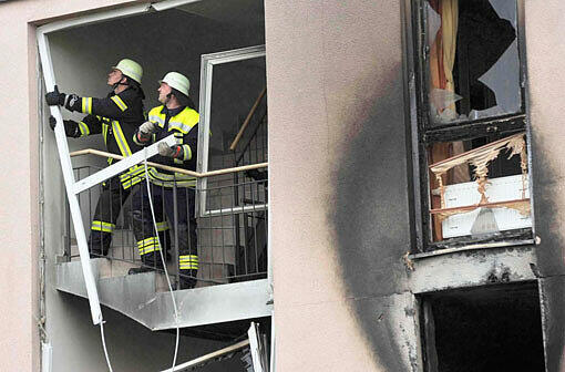 Feuerwehrleute begutachten die Schäden nach der Explosion in einem Wohnhaus in Ebersberg.