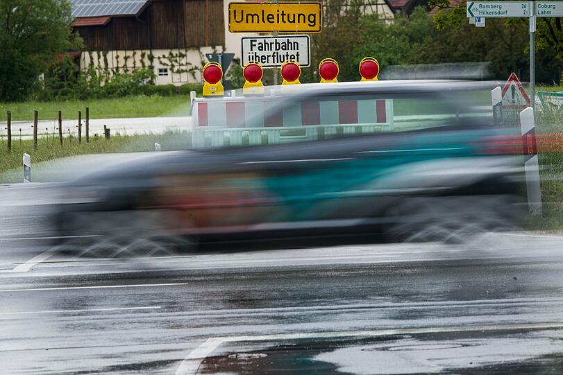 Auch die Landstraße zwischen Busendorf und Gleusdorf in der Nähe von Bamberg ist überflutet. Ein Warnschild informiert darüber.