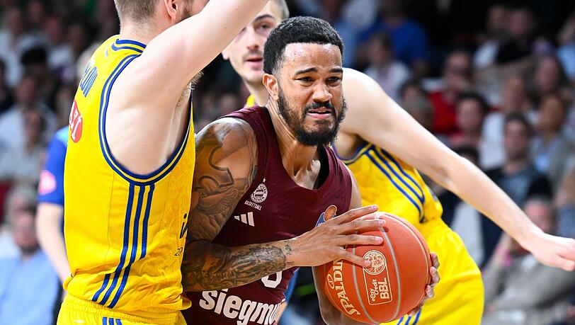 Nick Weiler-Babb (M) von München und Malte Delow (l) von Berlin kämpfen um den Ball.