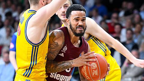 Nick Weiler-Babb (M) von München und Malte Delow (l) von Berlin kämpfen um den Ball.