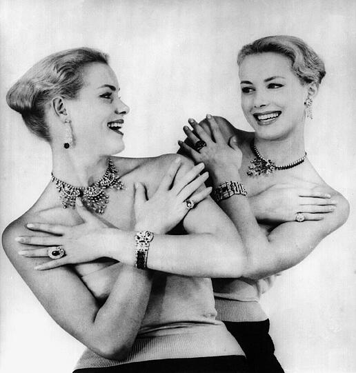 Reich behängt mit Schmuck lachen sich die deutschen Zwillinge Alice und Ellen Kessler an - aufgenommen am 05.10.1956 im Pariser Lido.